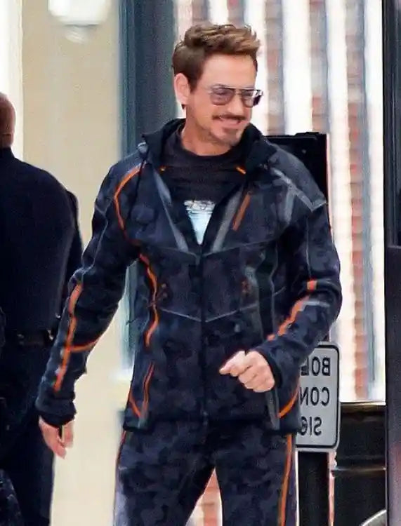 Person wearing a dark coat with orange accents on a city street